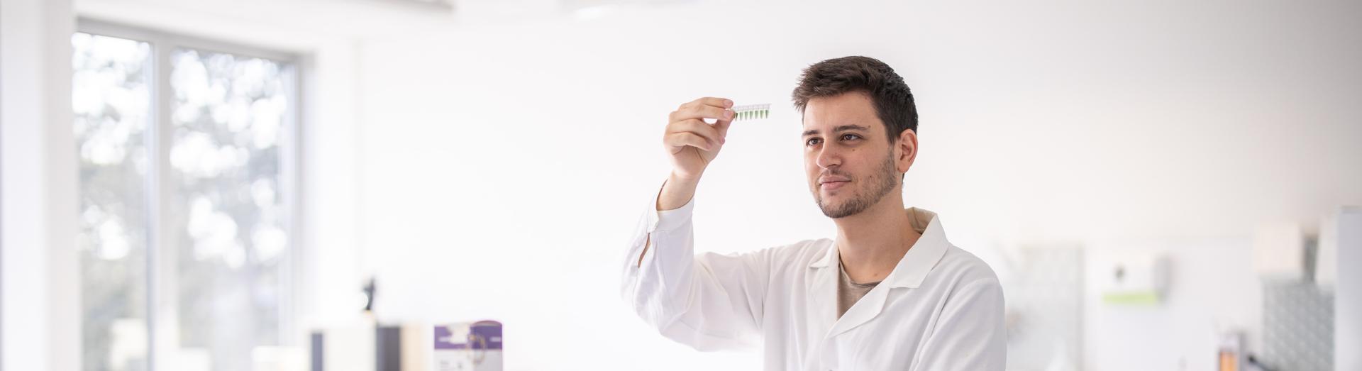 Forscher in Tullner Labor betrachtet wässrige Lösungen in kleinen Fläschchen