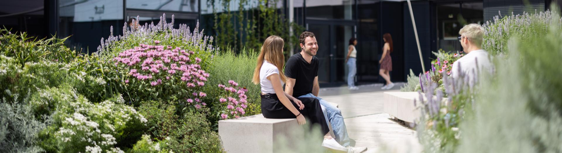 FH Studenten in Tulln vor dem Haus der Digitalisierung umgeben von Blumenschmuck