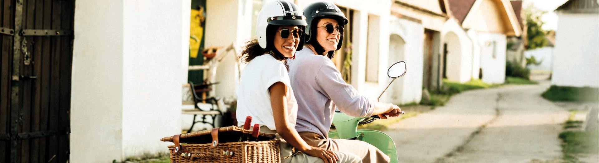 Zwei junge Frauen auf Moped in einer Kellergasse