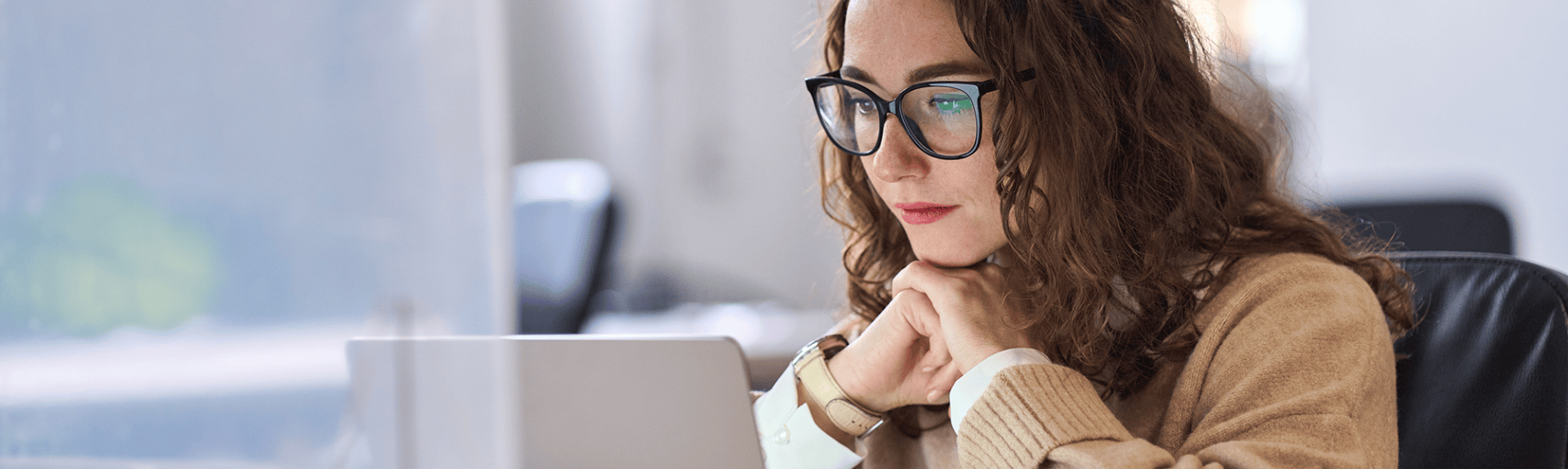 Junge Dame sitzt vor dem Laptop
