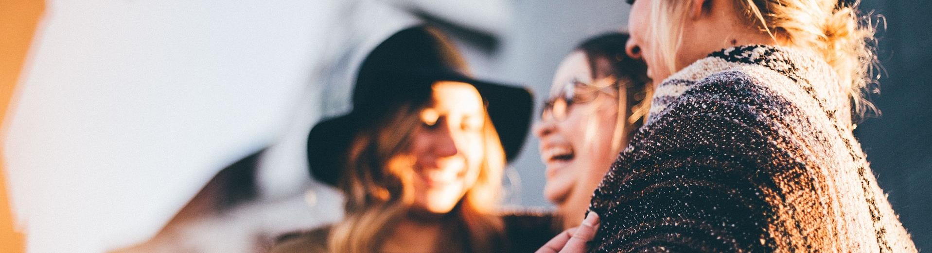 drei Frauen stehen nebeneinander und lachen