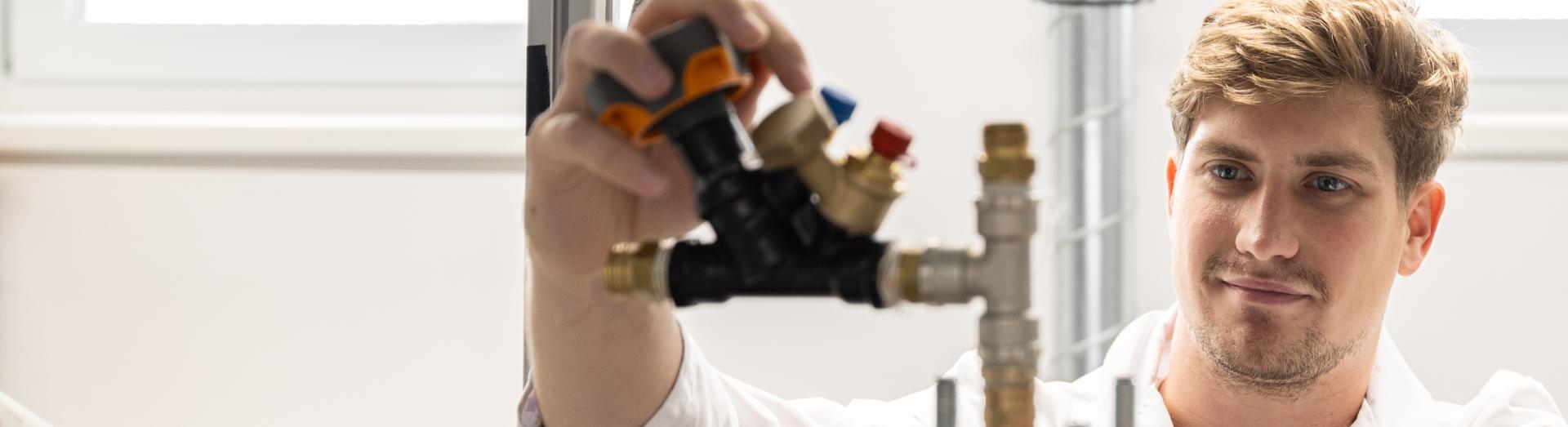 Mann arbeitet an einem Versuchsaufbau für Reibungs- bzw. Schmierungsoptimierung