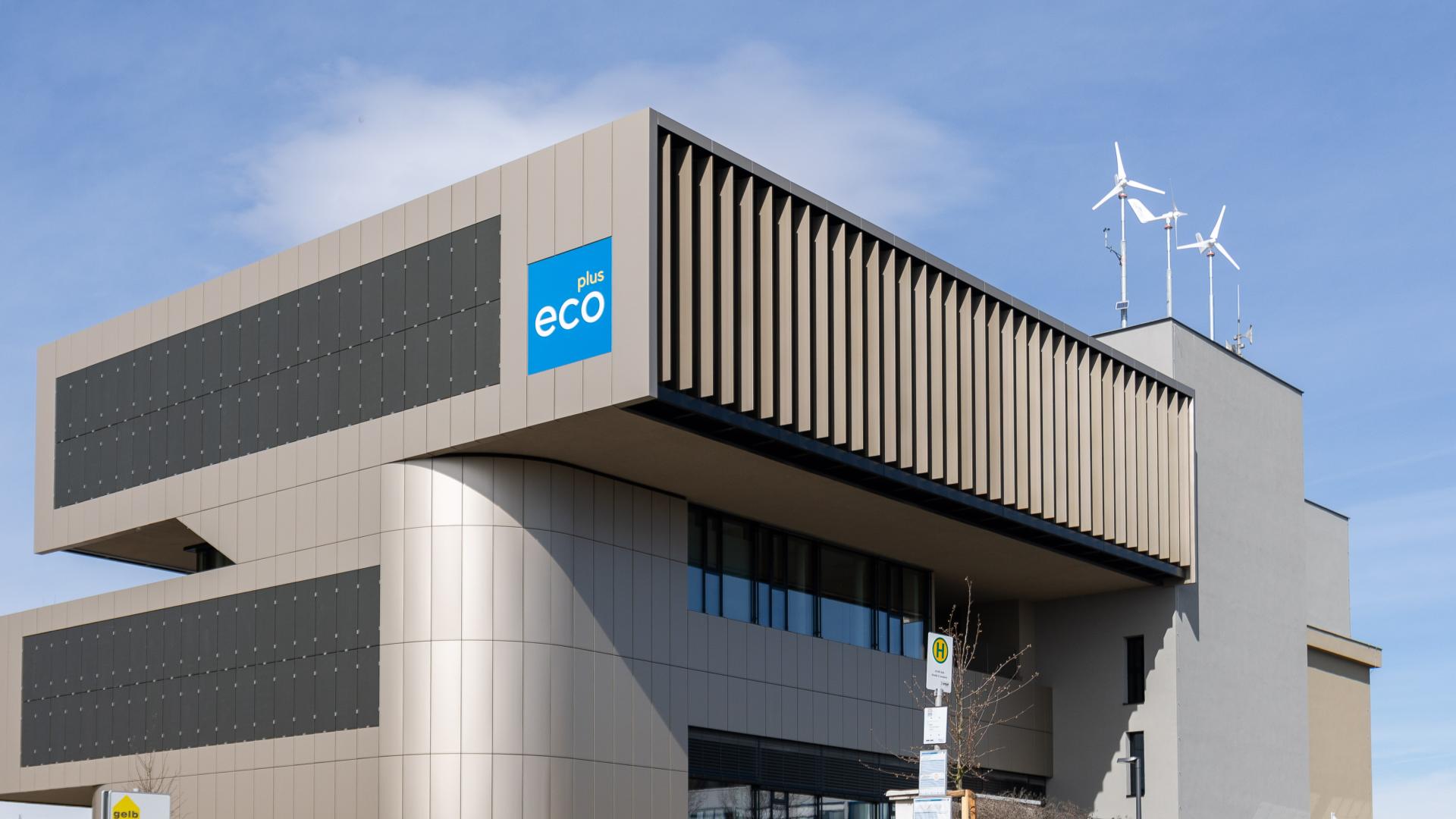 Neubau ecoforum im IZ NÖ-Süd mit kleinen Windrädern am Dach und Parkplätzen