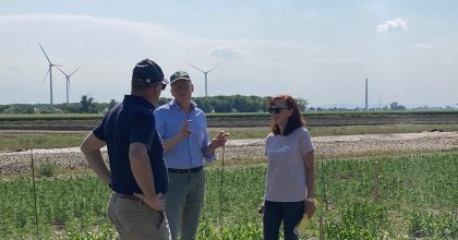 3 Personen stehen auf einer landwirtschaftlichen Fläche