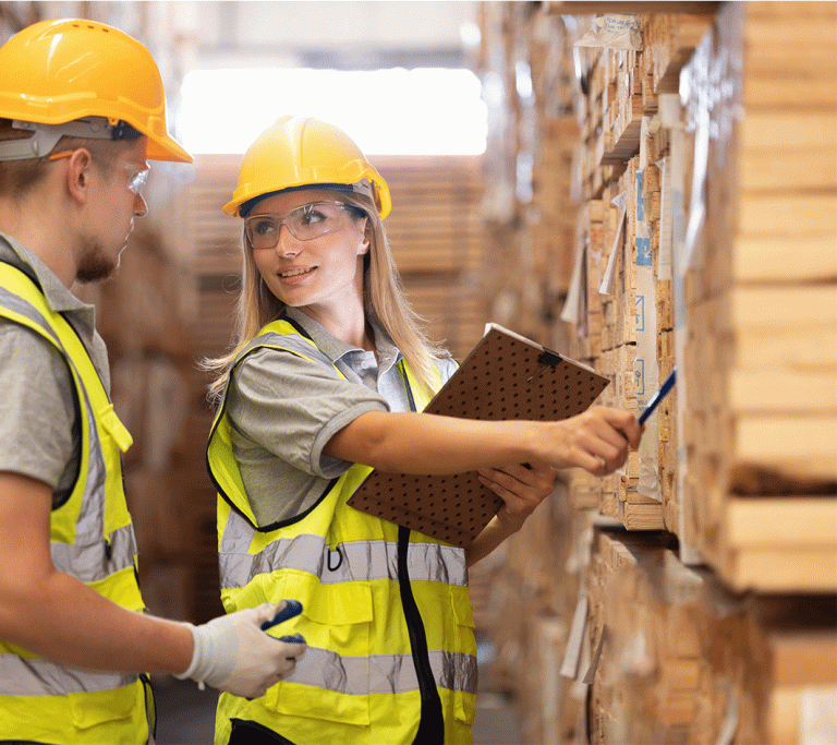 Zwei junge Angestellte überprüfen die Qualität von Holzprodukten bei der Ankunft
