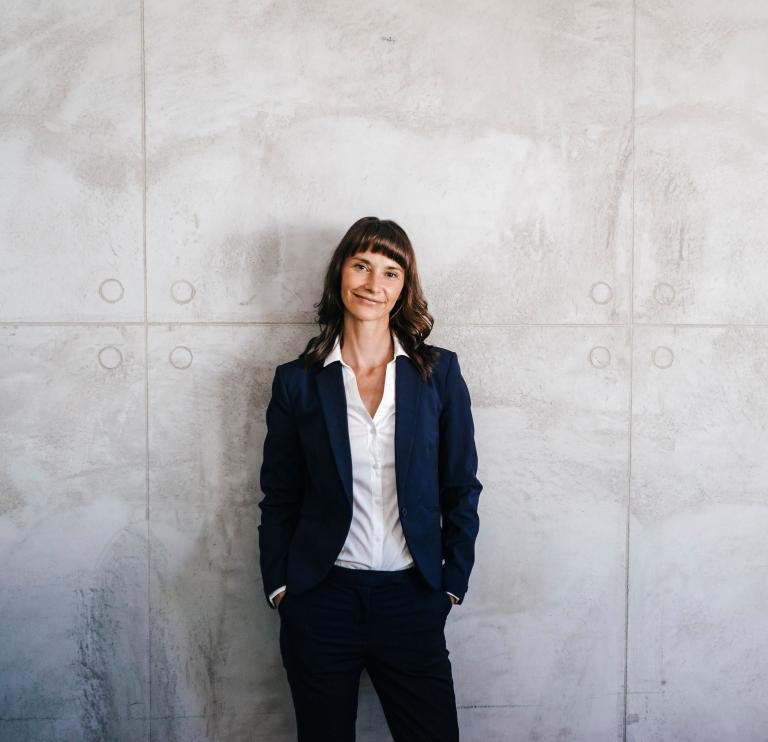 Frau vor grauer Wand