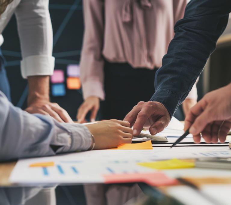 viele Hände arbeiten an einem Projektplan