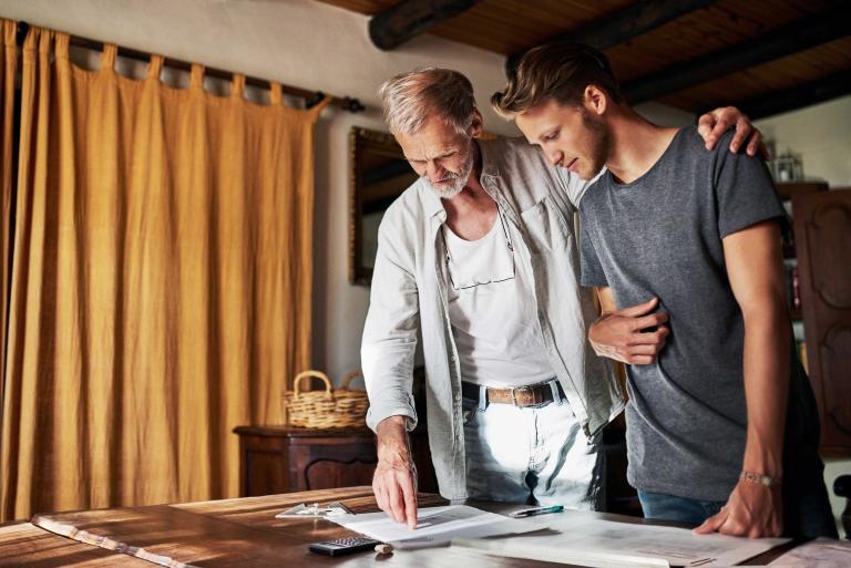Father and son discuss documents on the table together