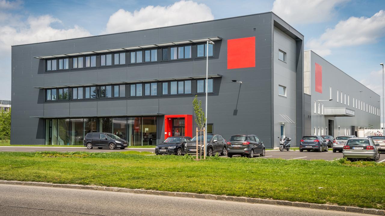 Außenansicht Mietobjekt M22 mit geparkten Autos im IZ NÖ-Süd