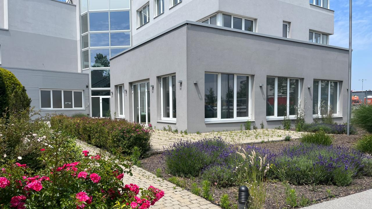 mehrstöckiger Gebäudekomplex mit einem Garten im Vordergrund