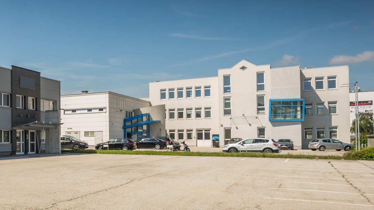 Mietobjekt M12 mit blau hervorgehobenen Fensterpartien und parkenden Autos davor