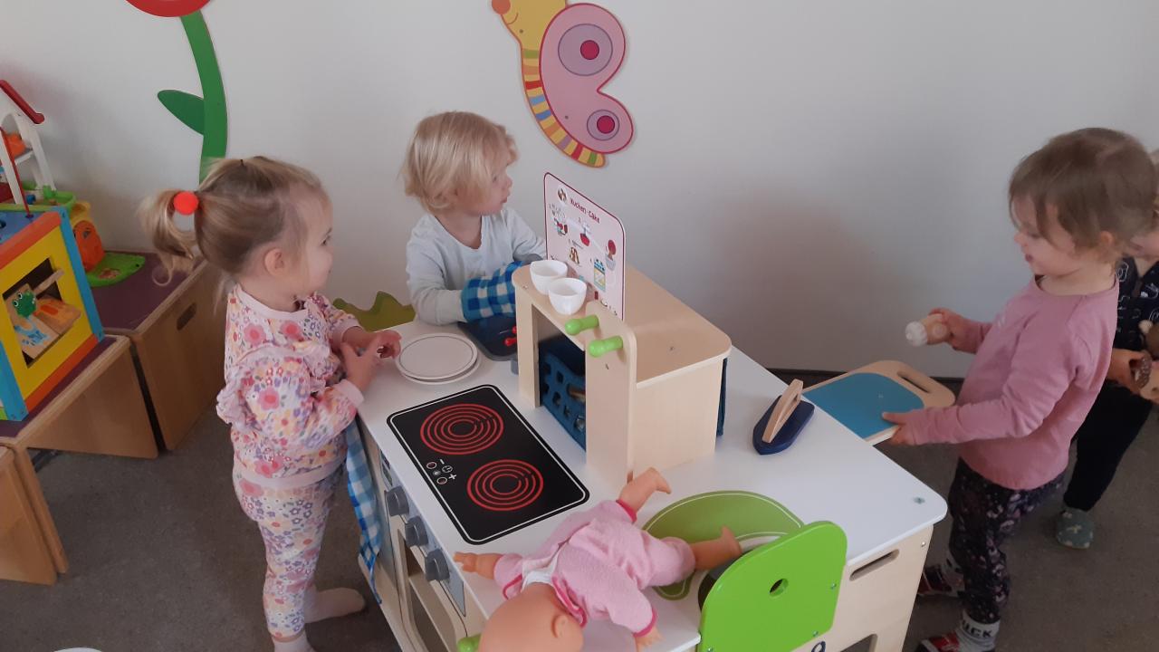 Spielende Kinder in der Puppenküche