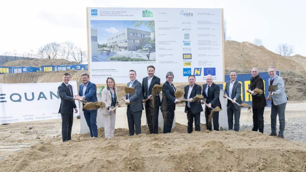 Personen stehen nebeneinander und haben einen Spaten in der Hand