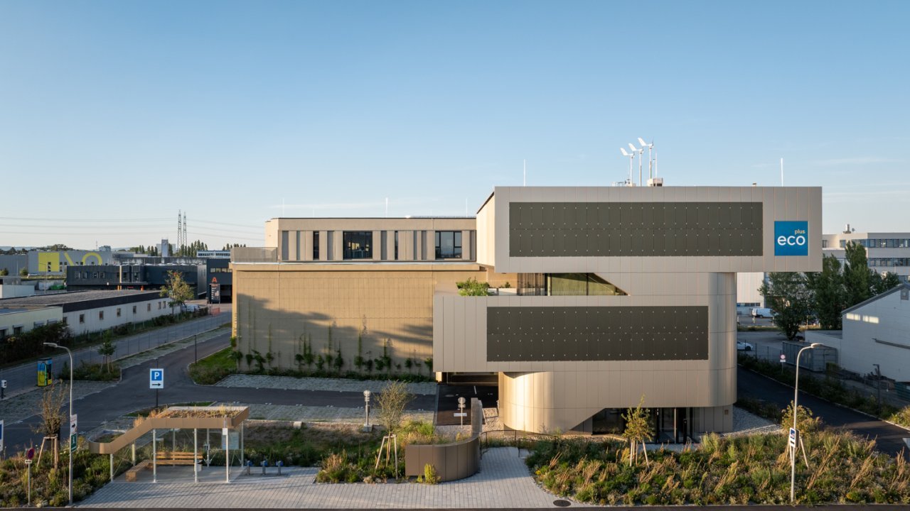 Außenansicht eines modernen Büro- und Veranstaltungsgebäudes mit goldener Fassade im Abendlicht 