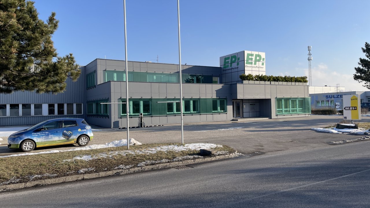 Außenansicht eines Mietobjektes mit grünen Fenster und Parkplatzim IZ NÖ-Süd