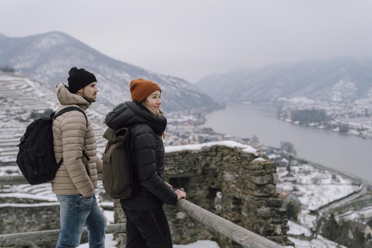 Junges Pärchen schaut in der Wachau auf die verschneite Donaulandschaft