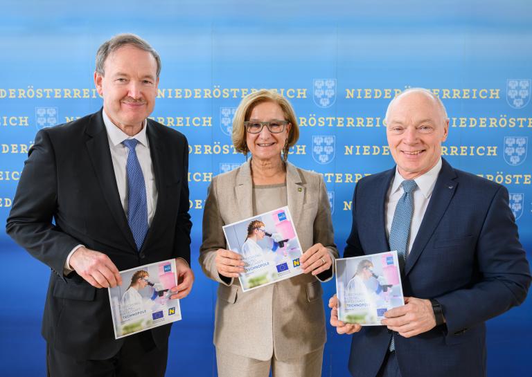 Drei Personen halten neuen Technopolfolder vor einer großen Niederösterreich-Rückwand in die Kamera