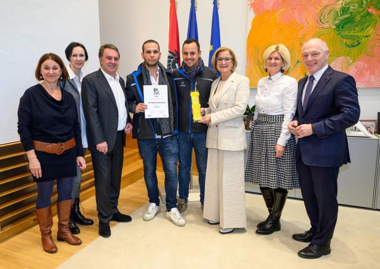 Personen stehen nebeneinander und lachen in die Kamera
