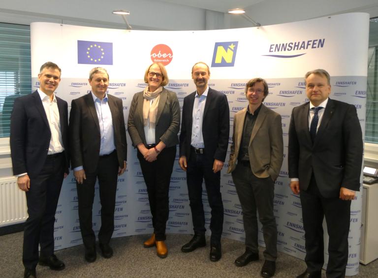 Gruppenfoto mit 5 Herren und einer Frau vor Ennshafen Rückwand
