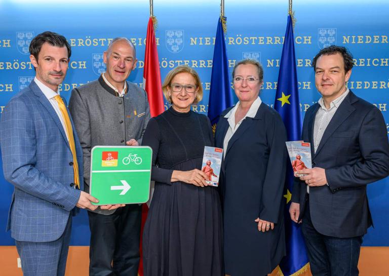 Personenfoto mit 2 Frauen und 3 Herren die Radtafel und Radfahrflyer in der Hand halten