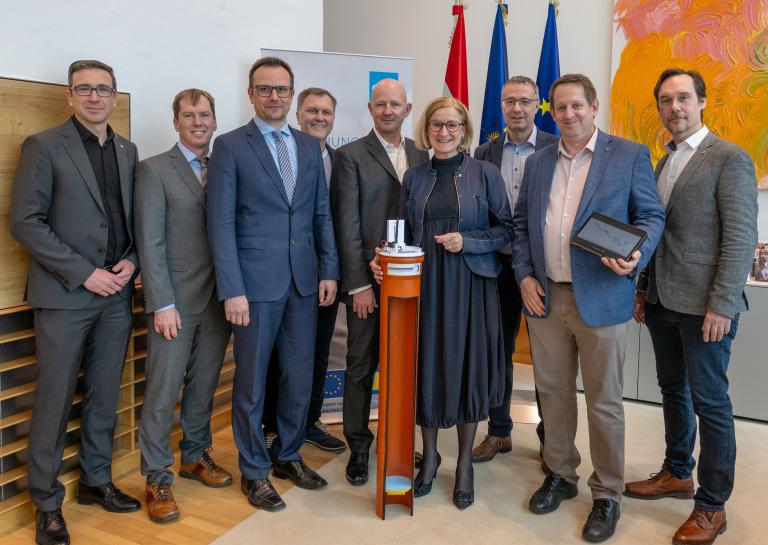 Personenfoto mit 8 Männern rund um Landeshauptfrau Mikl-Leitner