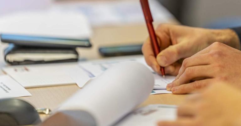 Fortbildungsszene an einem Tisch mit Papierunterlagen