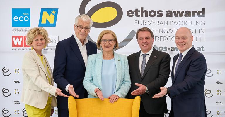 Gruppenfoto 5 Personen hinter gelben Sessel vor ethos award Zip up