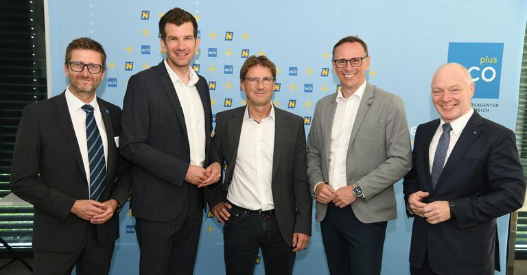 5 Männer stehen vor einer ecoplus Rückwand und schauen in die Kamera
