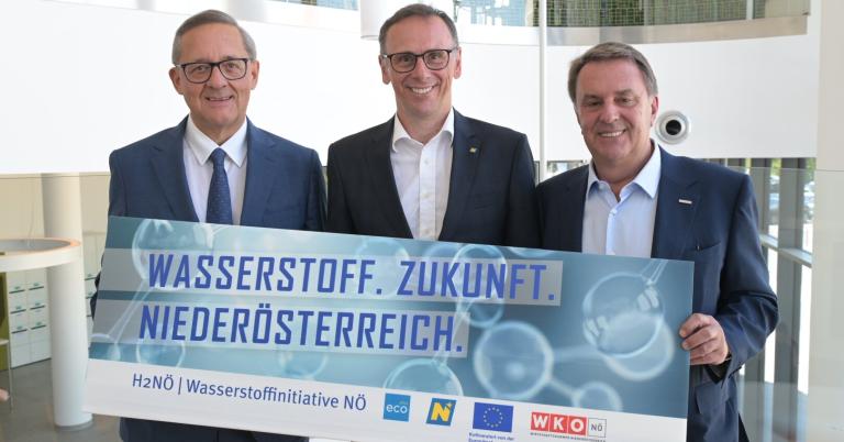 Drei Personen halten Schild