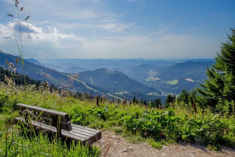 Ausblick auf Berge und eine Bank im Vordergrund