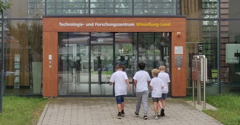 Vier Kinder hören Vortragendem zu