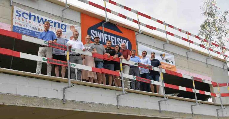 Großes Gruppenfoto vor Rohbau - anlässlich Gleichenfeier Firma Schweng