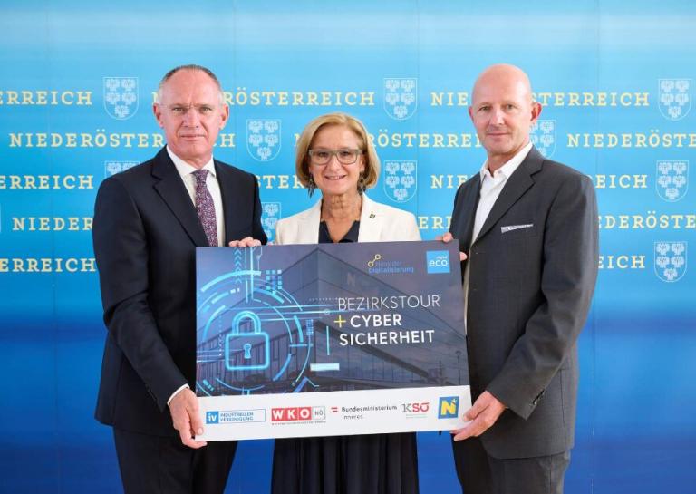 drei Personen stehen in einer Reihe und halten eine Fototafel  mit Cyber Sicherheit