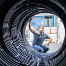 Mann blickt durch Abwasserrohre