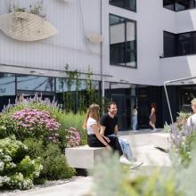 FH Studenten in Tulln vor dem Haus der Digitalisierung umgeben von Blumenschmuck