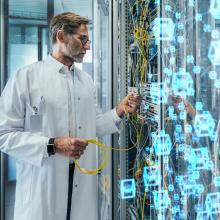 Älterer männlicher Techniker beim Einstecken von Glasfaserkabeln im Rechenzentrum