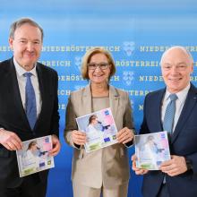 Drei Personen halten neuen Technopolfolder vor einer großen Niederösterreich-Rückwand in die Kamera