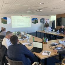 Mehrere Menschen sitzen beim Projektmeeting in einem Workshopraum