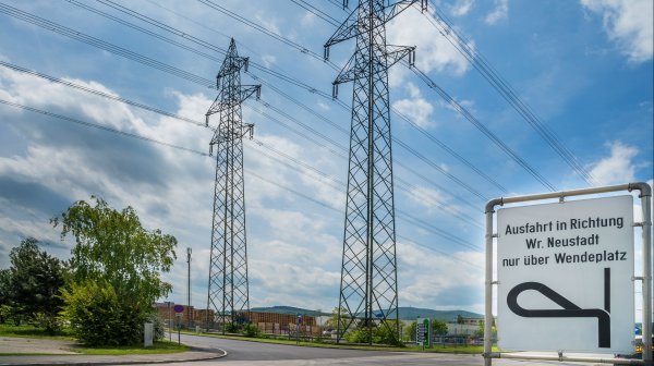 Hochspannungsleitung mit 2 Freileitungsmasten und einer Verkehrstafel im IZ NÖ-Süd