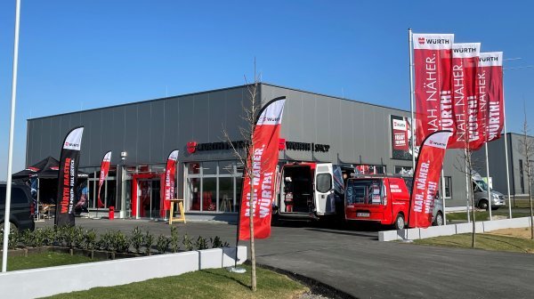 Firmengebäude Würth bei der Eröffnung mit vielen roten Würth-Fahnen