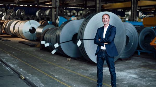 Business Man in Lagerhalle mit Kabeltrommeln