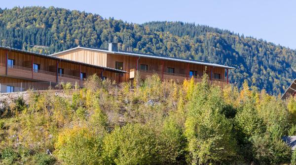 Seitenansicht Hotel mit Holzwänden umgeben von Wald