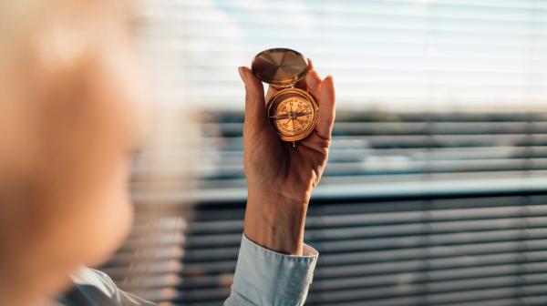 Unscharfe Aufnahme einer Person mit einem Kompass in der Hand