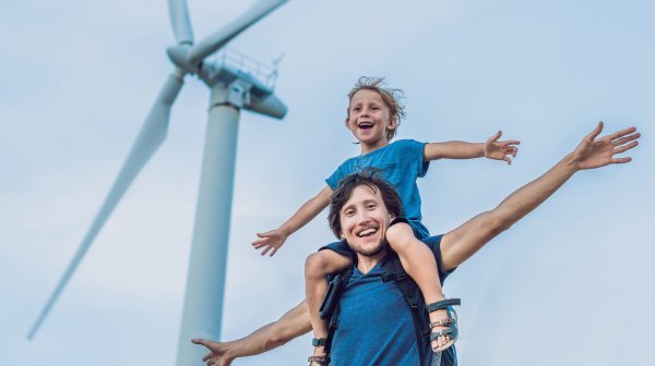 Windrad mit Mann und Kind auf Schultern