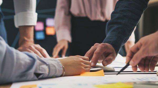 viele Hände arbeiten an einem Projektplan