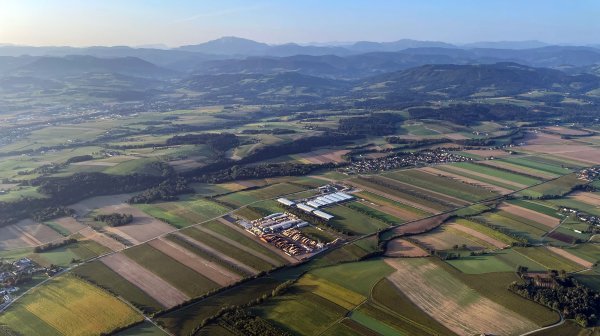 Luftbild Wirtschaftspark Wolfpassing mit vielen umgebenden Feldern und Hügeln im Hintergrund