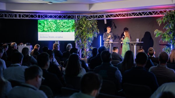 Raum mit Leuten auf einer Messeveranstaltung bei einer Präsentation mit Bildschirm