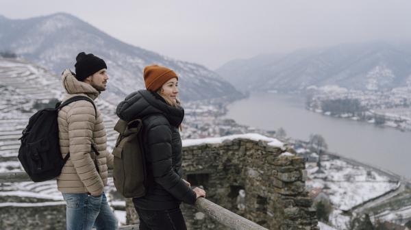 Junges Pärchen schaut in der Wachau auf die verschneite Donaulandschaft