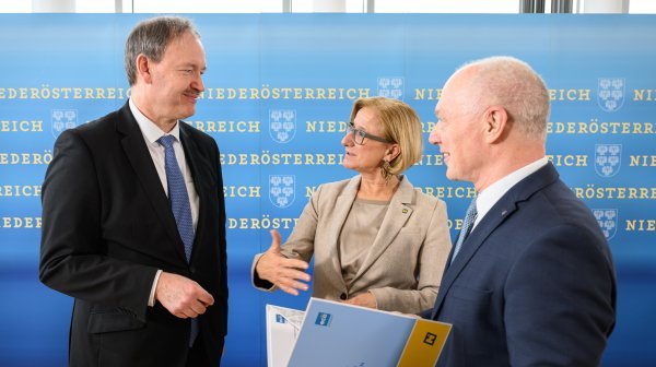 Drei Personen stehen vor einer großen Niederösterreich-Wand