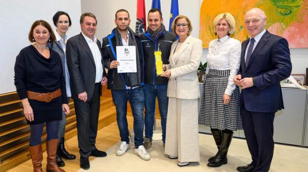 Personen stehen nebeneinander und lachen in die Kamera